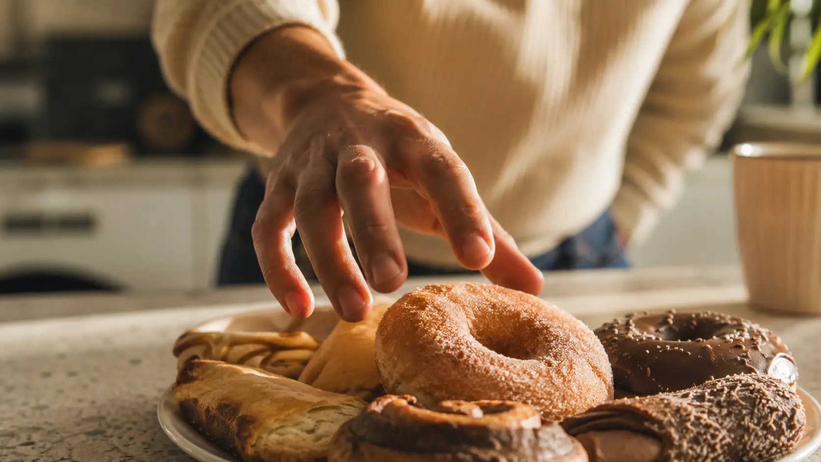 A person reaching for a sugary snack, illustrating the moment a sugar craving hits